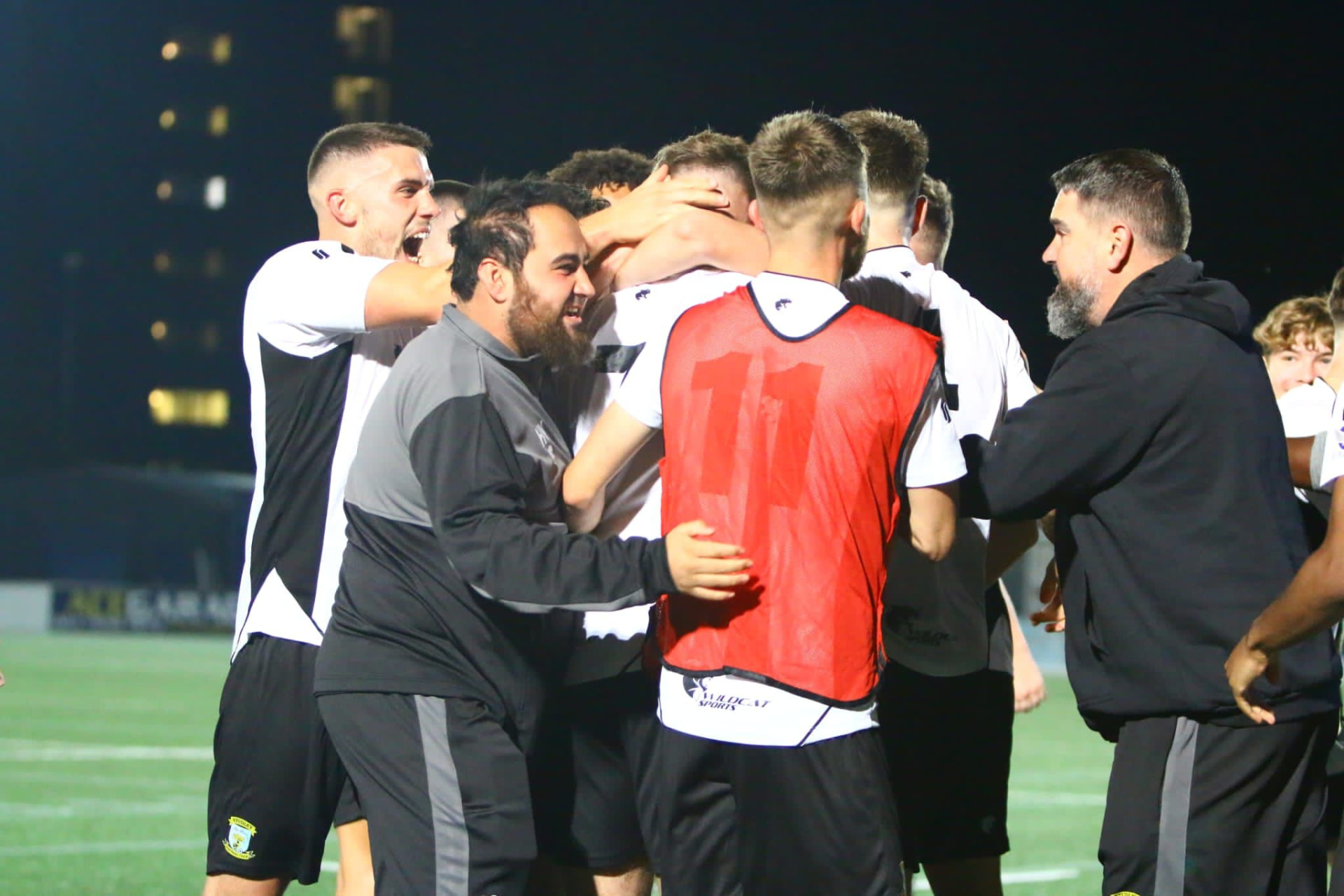 Huzefa Vorajee celebrating pitchside with his squad after a match